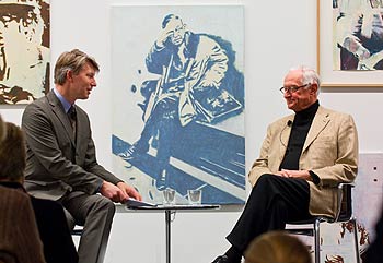 zwei Herren auf dem Podium vor einem Gemälde